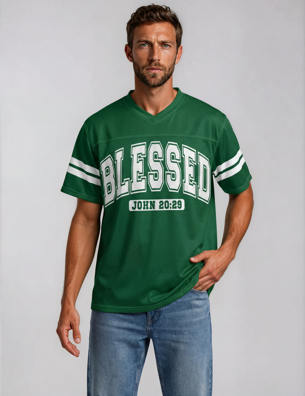 Man wearing a green 'BLESSED' t-shirt with blue jeans on a plain background